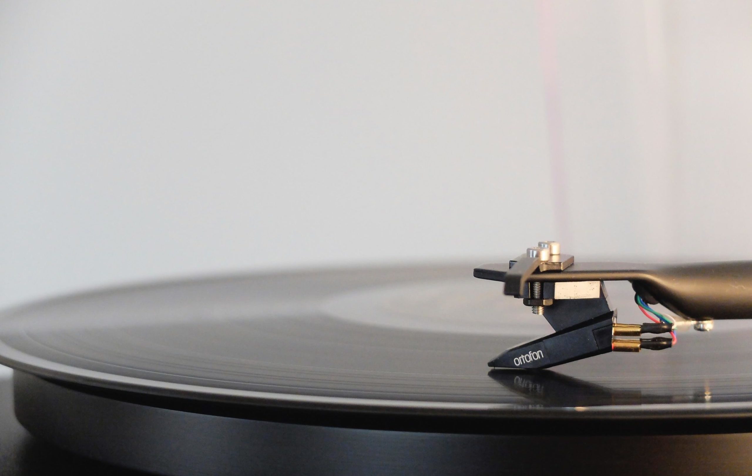 A black turntable with a stylus on it.